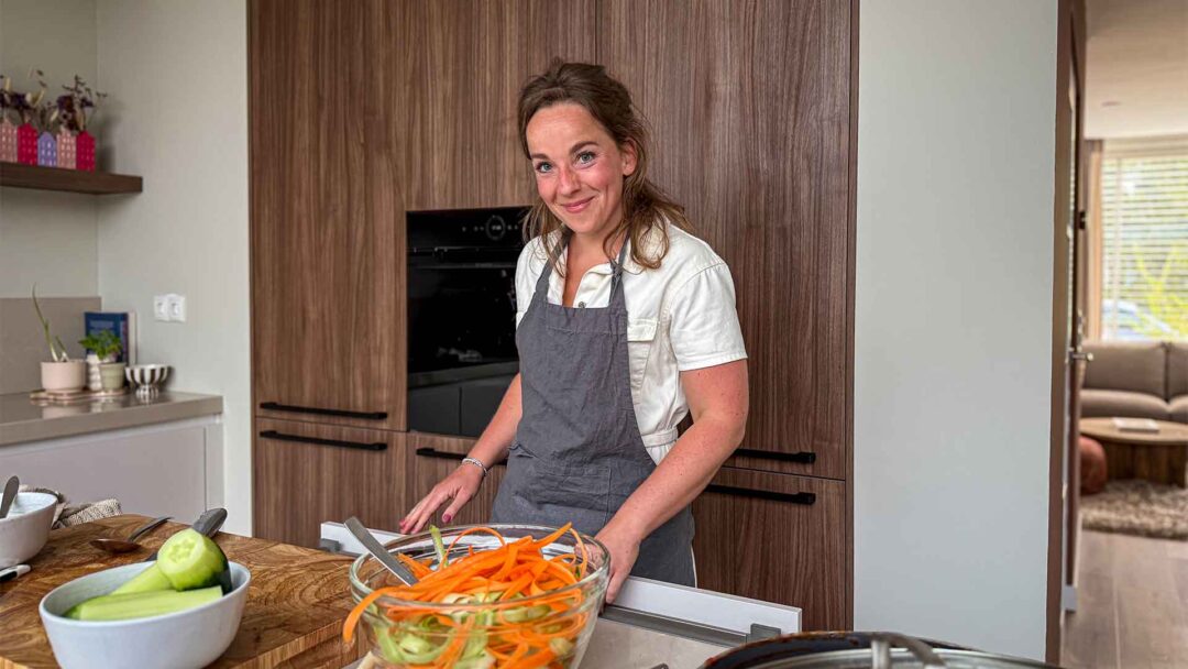 een jonge vrouw staat te koken in een keuken
