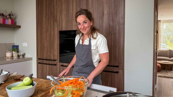 een jonge vrouw staat te koken in een keuken